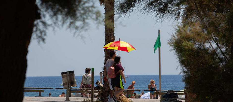 Dos personas se protegen del sol en la Barceloneta