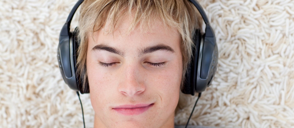 Un joven escuchando música, que tiene efectos terapéuticos
