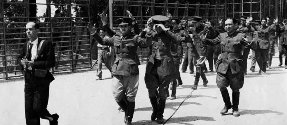 Rebel officers, with their hands raised, are marched under armed guard from the Montana barracks in Madrid, July 27, 1936.  A few moments later they were sentenced to death and shot, the start of the "red terror."  (AP Photo)
