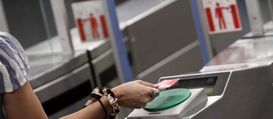 Una mujer pasa su billete en el torno del Metro madrileño