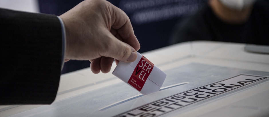Un miembro del Servel (Servicio Electoral) muestra cómo emitir su voto en un simulacro electoral