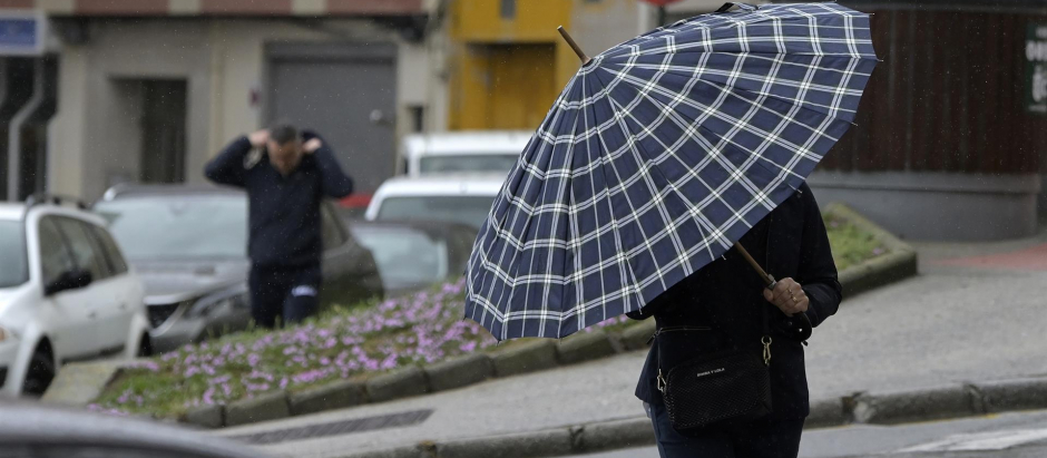 Una persona con paraguas camina por el centro de La Coruña