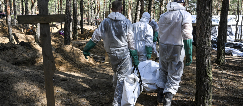 Forenses ucranianos recuperan un cadáver de la fosa común en un bosque en las afueras de Izyum