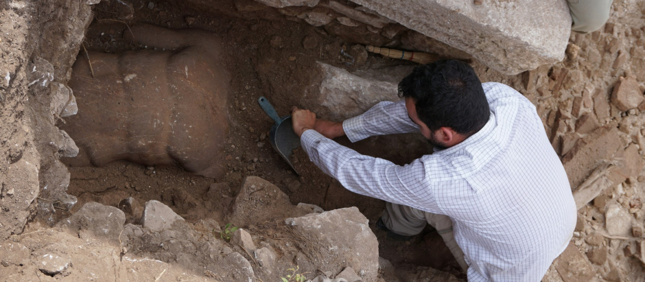 Uno de los arqueólogos desenterrando la estatua de Hércules