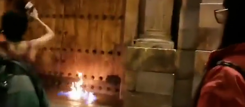 Captura del video donde se ve cómo las activistas preden fuego a la puerta de la catedral
