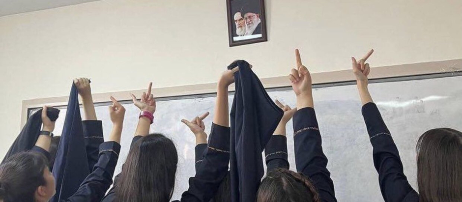Alumnas de un instituto de Irán le hacen la peineta a los retratos de los ayatolás Jamenei y Jomeiní