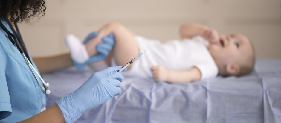 Una enfermera vacunando a un bebé