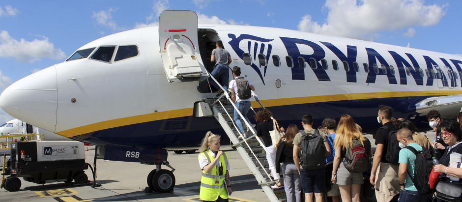 Un grupo de turistas se prepara para montarse en un avión de la compañía de bajo coste Ryanair