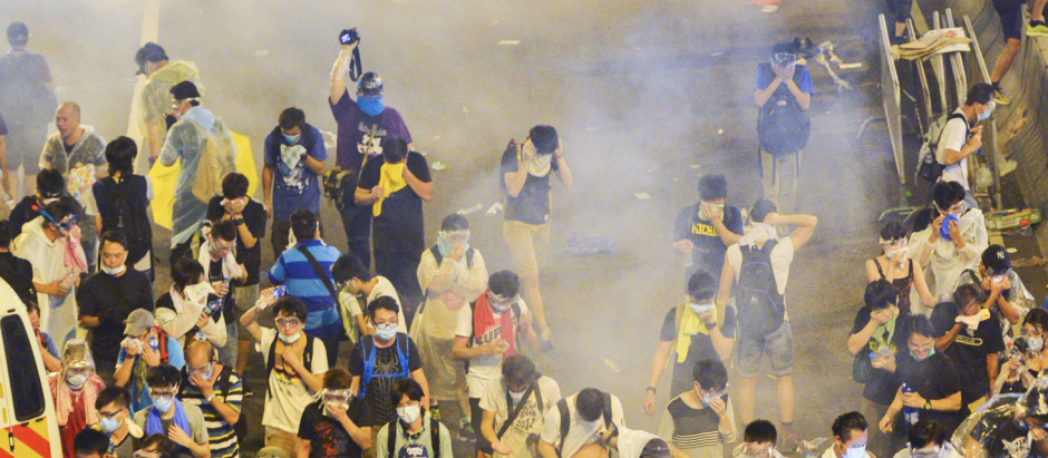 Prodemocracy protesters in Hong Kong flee amid tear gas fired by riot police in the evening of Sept. 28, 2014.