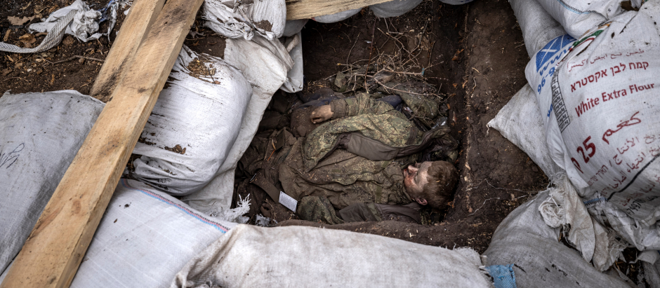 EDITORS NOTE: Graphic content / -- AFP PICTURES OF THE YEAR 2022 --

The body of a Russian soldier lays in a trench after the Ukranian troops retook the village of Mala Rogan, east of Kharkiv, on March 30, 2022. - The village of Mala Rogan was recaptured over the weekend, but it took nearly three days to fully clear the area, with Ukrainian troops going from house to house to look for Russian soldiers who had taken refuge in cellars. On March 30, 2022, an ambulance was collecting dead bodies in bags. (Photo by FADEL SENNA / AFP) / AFP PICTURES OF THE YEAR 2022