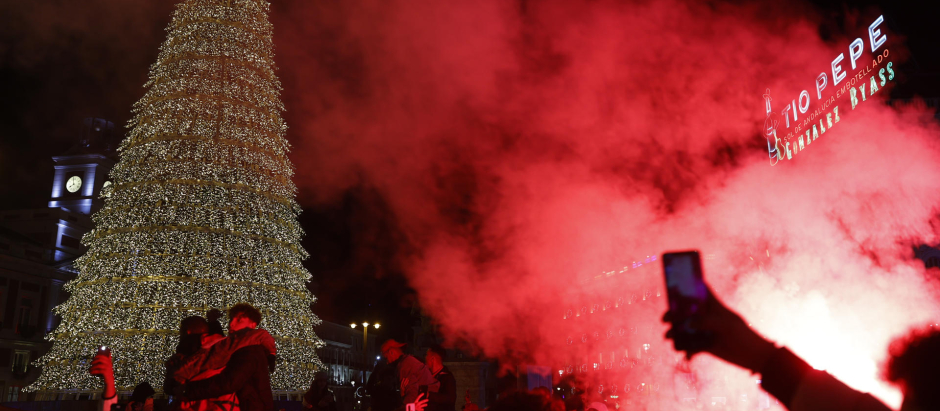 Aficionados marroquíes prenden bengalas junto al árbol de Navidad de la Puerta del Sol, en Madrid