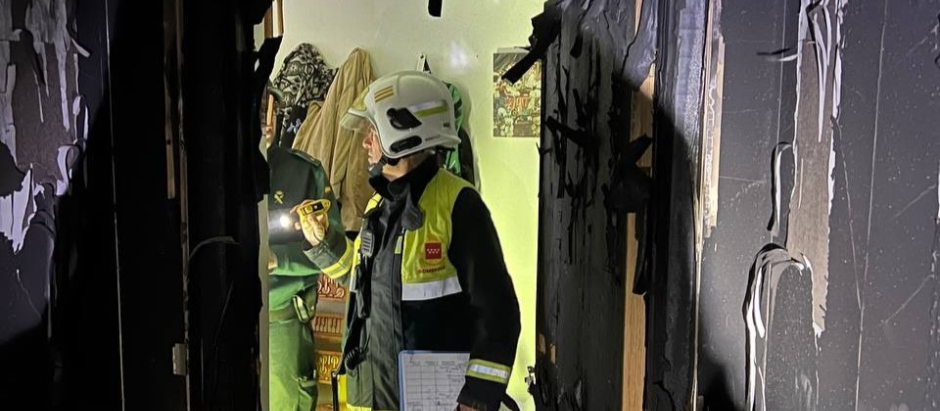 Un bombero, en el interior de una de las viviendas afectadas por el fuego en Collado Villalba, Madrid