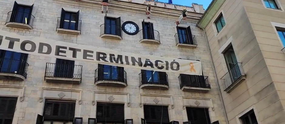 Cartel de 'Autodeterminación', con el lazo amarillo del separatismo catalán, colgado en la fachada del Ayuntamiento de Gerona