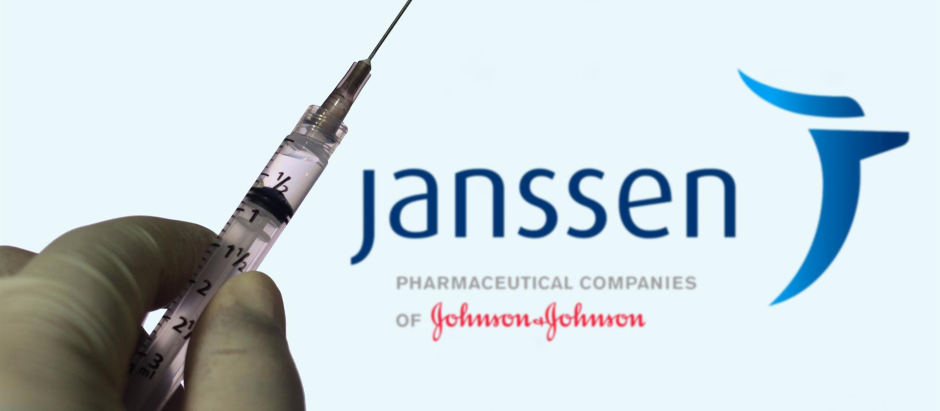 Una mano sujeta una vacuna con el logo de la compañía farmacéutica Janssen en el fondo