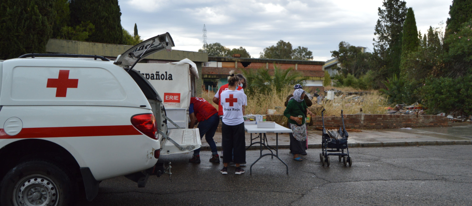 Imagen de personal de Cruz Roja visitando uno de los asentamientos de inmigrantes a los que atienden.