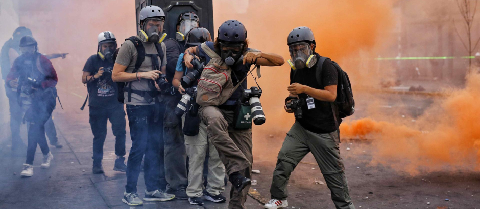 Fotorreporteros y miembros de la prensa cubren los enfrentamientos entre manifestantes y la Policía durante una nueva jornada de protestas antigubernamentales en Lima