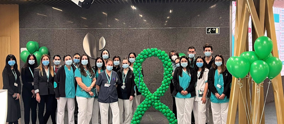 Profesionales del Hospital Quirónsalud Córdoba junto a globos y lazo de color verde, que representa la lucha contra el cáncer