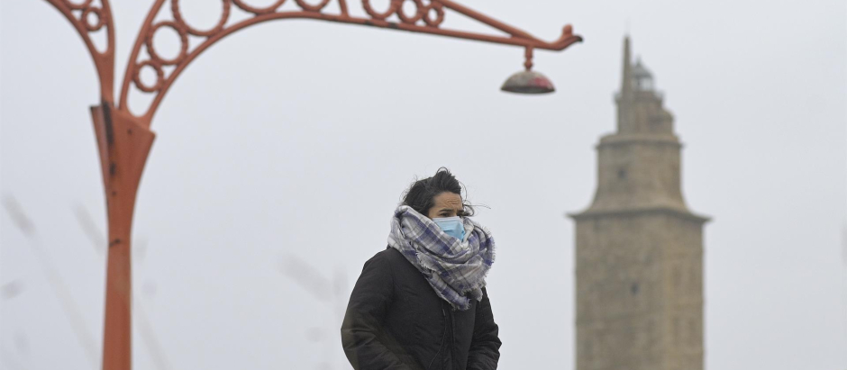 Una persona camina protegida del frío en el Paseo Marítimo de La Coruña