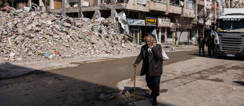 Un hombre pasea entre los edificios derruidos por el terremoto en la ciudad de Antakya