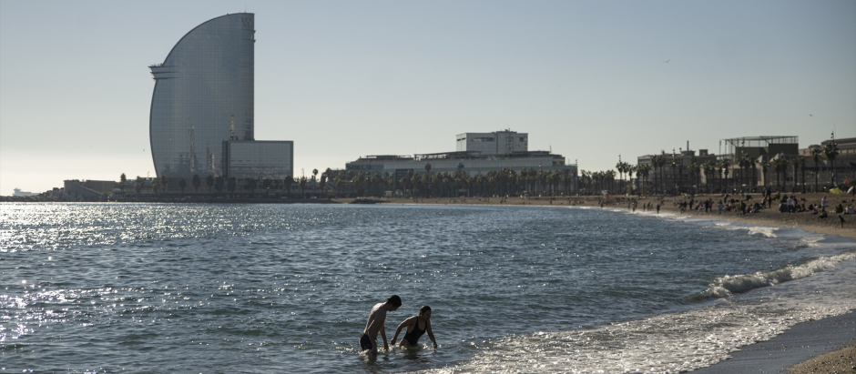 Una pareja se baña en la playa de la Barceloneta, en Barcelona