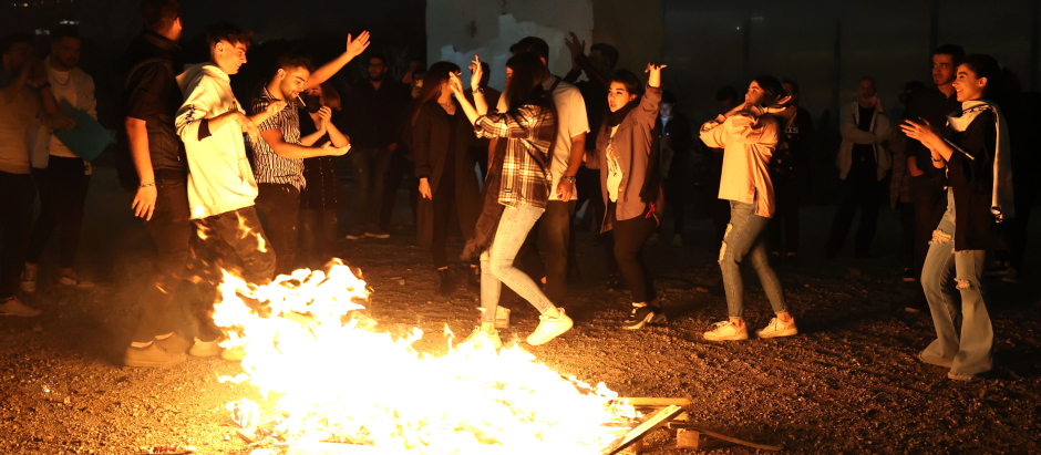 Los iraníes bailan alrededor de una fogata durante la fiesta del fuego el martes
