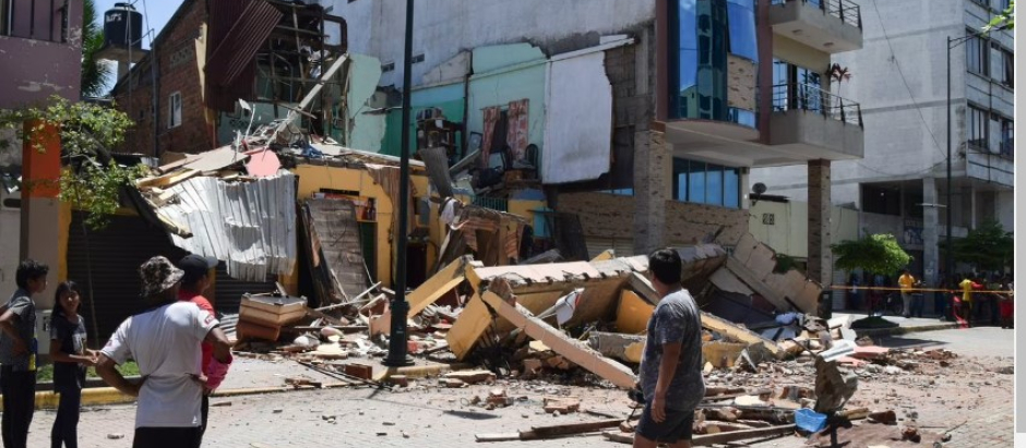 Los residentes miran un edificio que se derrumbó después de que un terremoto sacudiera Machala, Ecuador