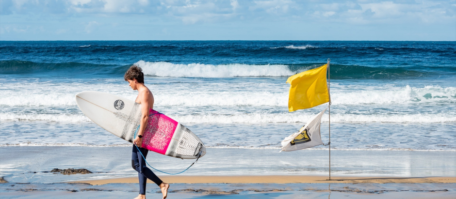 Un surfista pasea por la playa de las Canteras, en Las Palmas de Gran Canaria