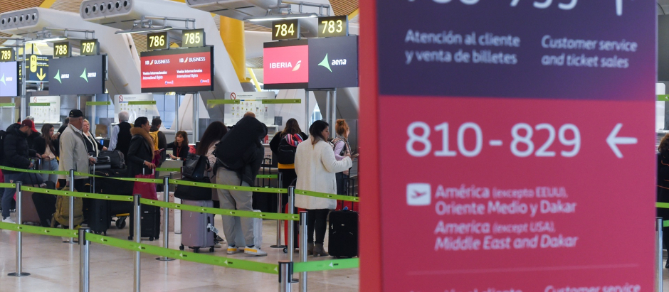 Varias personas esperan para embarcar y facturar en la zona de salidasTerminal 4 del Aeropuerto Adolfo Suárez Madrid-Barajas