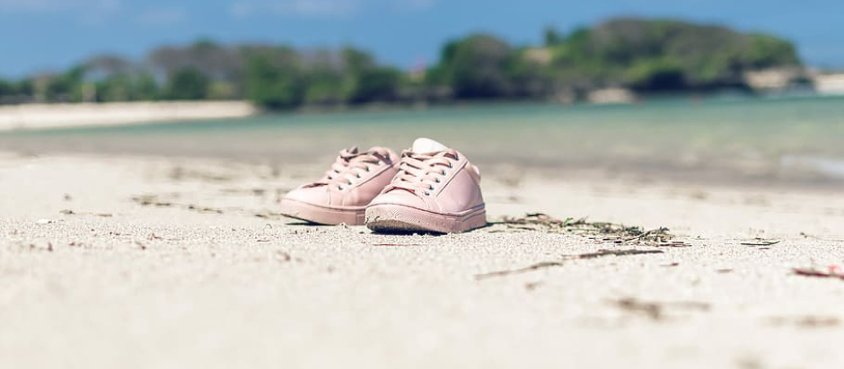 Un par de zapatillas en una playa