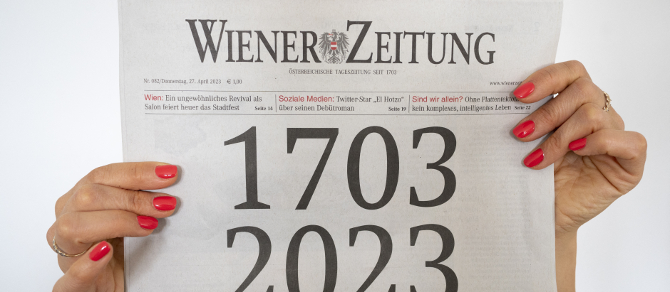 Una mujer sostiene la edición actual del periódico "Wiener Zeitung" del 27 de abril de 2023, cuya portada ilustra la antigüedad del periódico de 320 años