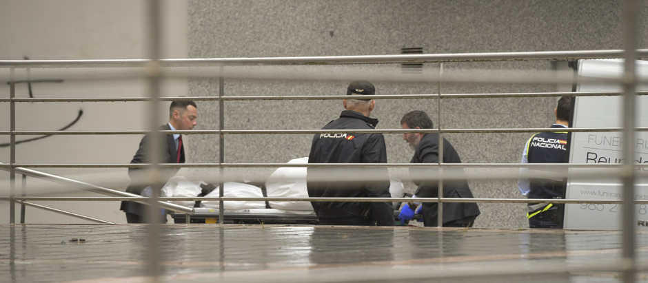 Operarios de una funeraria trasladan el cadáver de una de las dos niñas que se precipitaron por la ventana en Oviedo