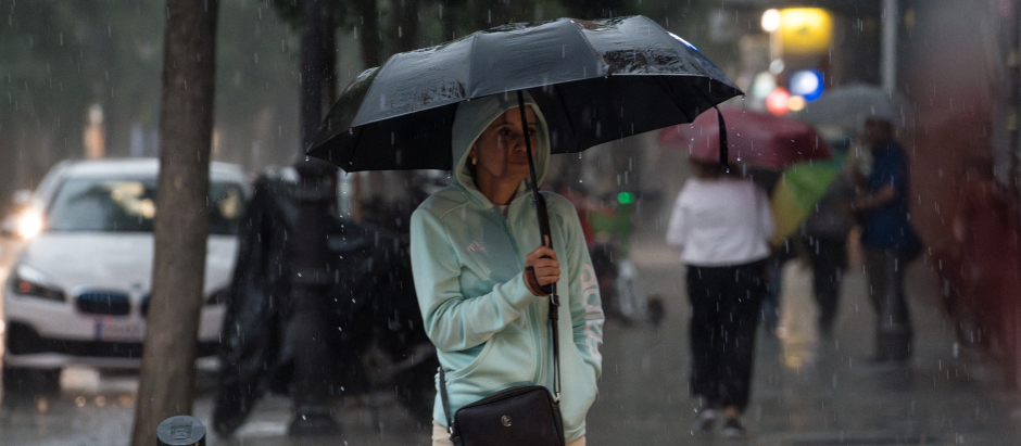 Una mujer con paraguas bajo la lluvia, a 29 de mayo de 2023, en Madrid