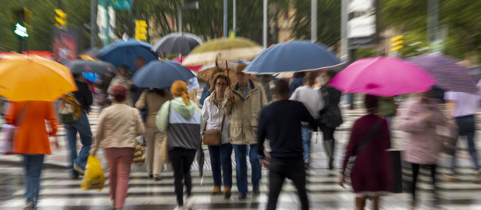 Varias personas se protegen de la lluvia caída este jueves en Zaragoza