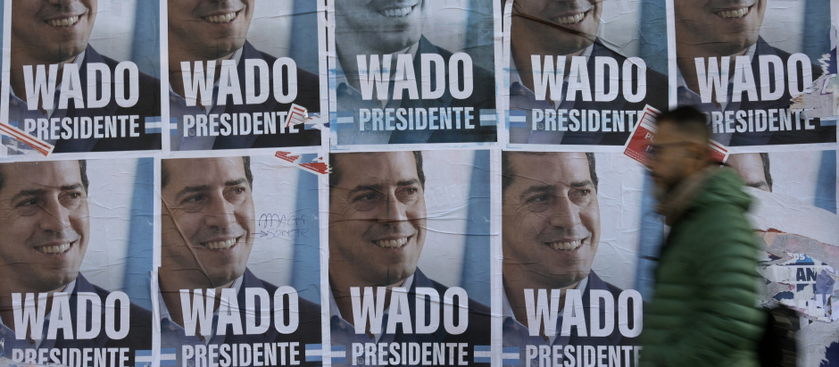 A man walks past banners with the portrait of Argentina's Interior Minister Eduardo De Pedro, better known as Wado, reading "Wado President", in Buenos Aires on June 12, 2023, ahead of the primary elections to be held on August 13. Eduardo De Pedro, son of a couple who disappeared during the last Argentine dictatorship, announced on June 22, 2023, his candidacy for president for Kirchnerism, the center-left wing of Peronism, on the way to the general elections of October 22. (Photo by JUAN MABROMATA / AFP)