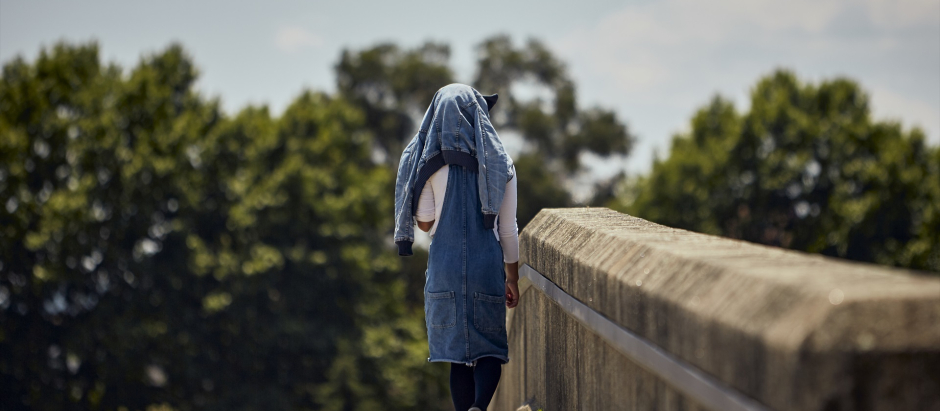 Una joven se tapa del calor con una chaqueta en la cabeza en Orense