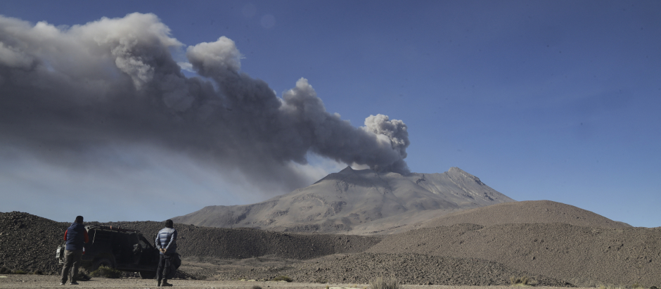 Varias personas observan la columna de humo que sale del volcán Ubinas, en Perú