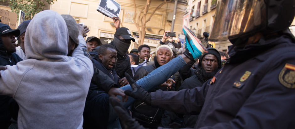 Un manifestante de origen subsahariano trata de patear a un agente de la Policía Nacional, en 2018, en Lavapiés (Madrid)