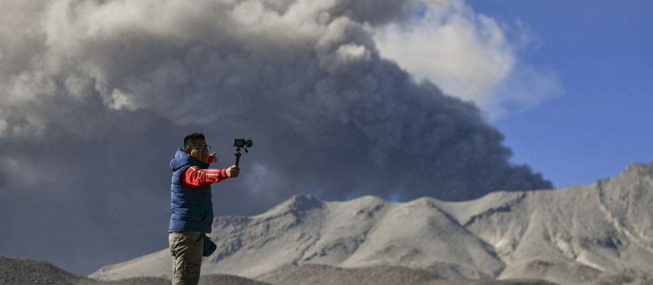 Un hombre saca una foto al volcán Ubinas, en Perú