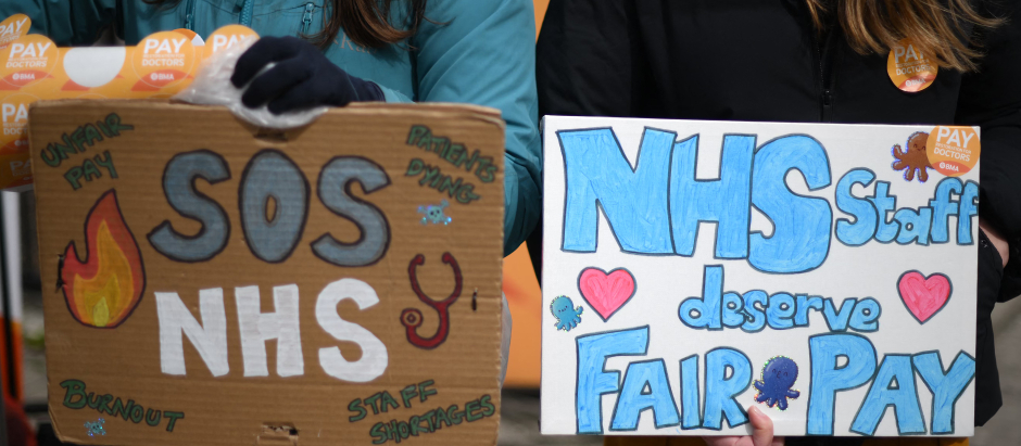 Manifestantes sujetan pancartas en favor del sistema nacional de salud británico