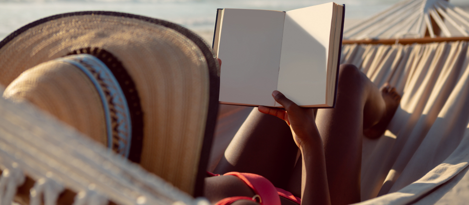 Una mujer leyendo en la playa
