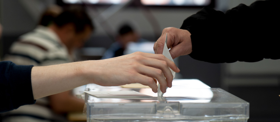 Un votante deposita su papeleta en la urna en un colegio electoral de Teruel