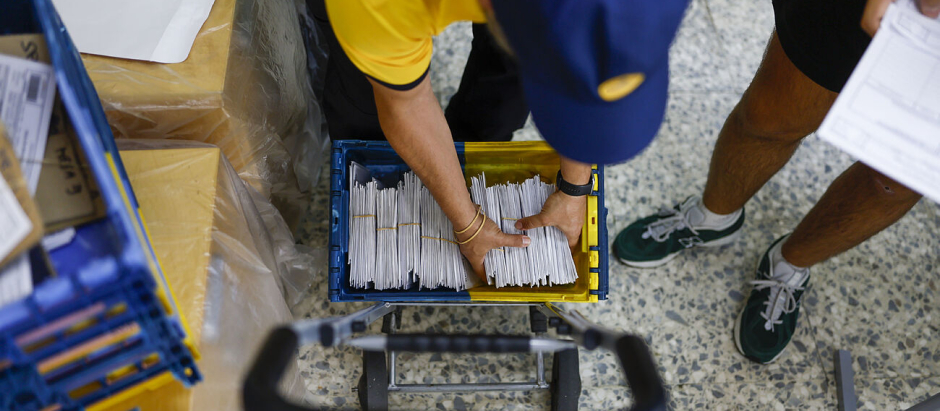 Un cartero entrega votos en el colegio Cristo Rey en Madrid. El voto por correo ha batido récord en esta cita electoral.
