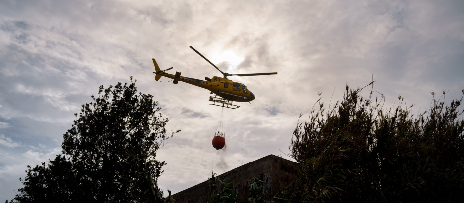 Un helicóptero recarga agua en el municipio de El Sauzal para atajar un foco situado en El Ravelo