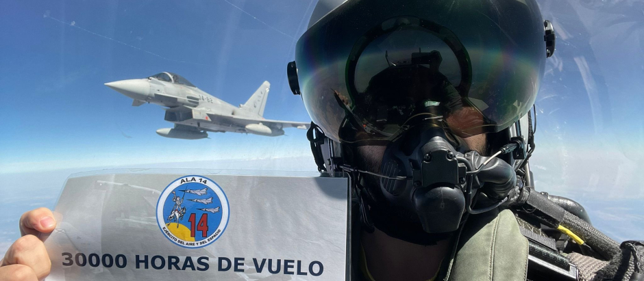 Un piloto muestra en pleno vuelo un cartel que acredita las 30.000 horas de vuelo de los Eurofighter en la base de Albacete