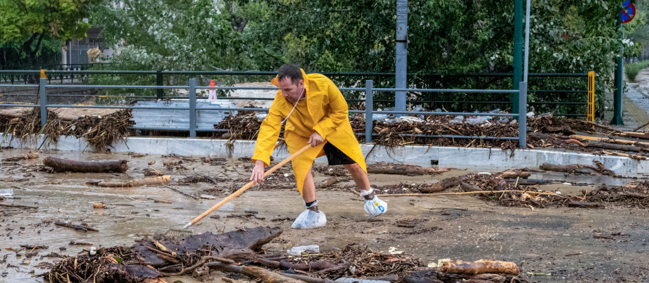 Un hombre retira trozos de madera y escombros en una zona inundada en Volos