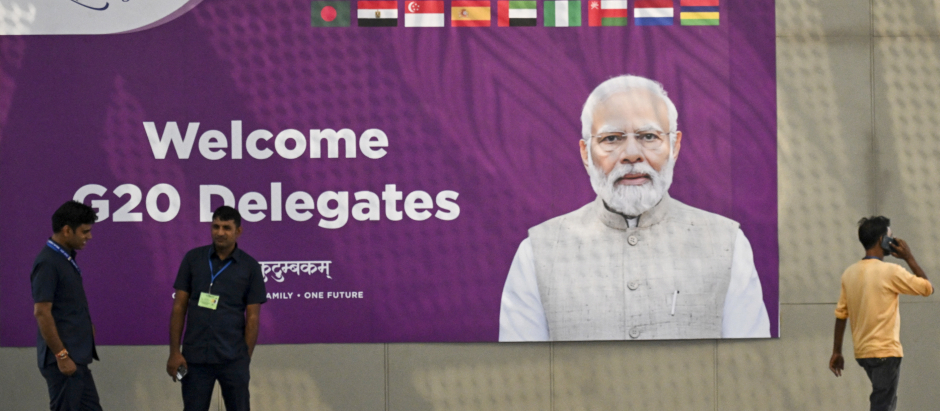 El personal de seguridad hace guardia cerca de un cartel de comunicación del G20 con el retrato del primer ministro de la India, Narednra Modi