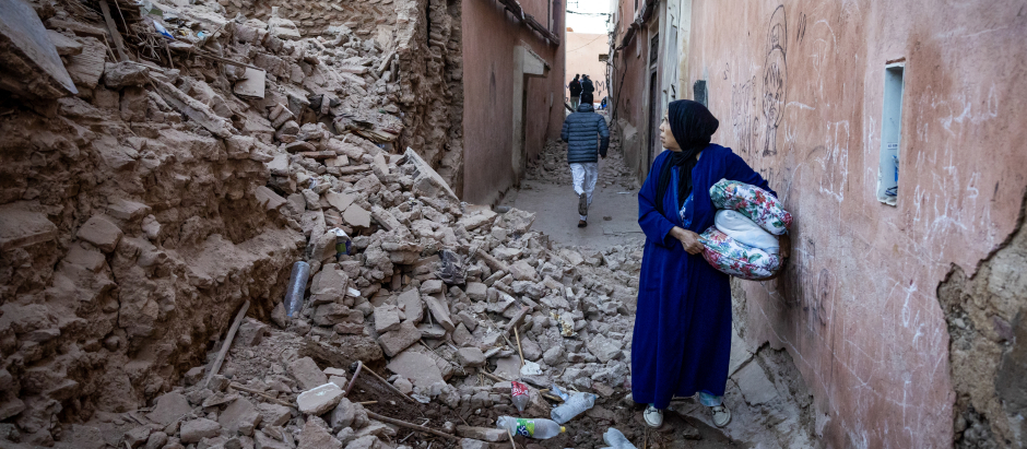 Una mujer mira los escombros de un edificio en la antigua ciudad de Marrakech