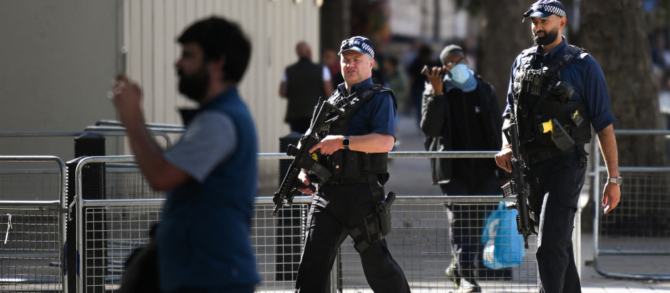 La policía metropolitana armada sostiene sus armas mientras patrulla cerca del Ministerio de Defensa británico