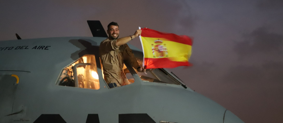 Un militar ondea la bandera española desde el avión del Destacamento Orión