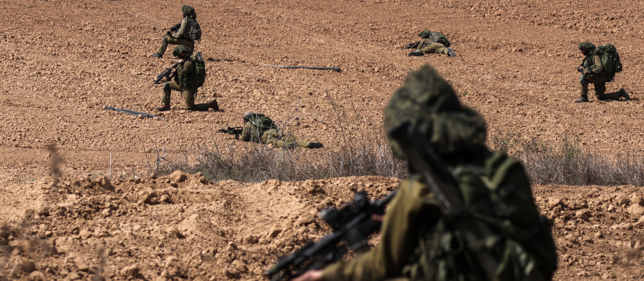 Soldados israelíes toman posición en un campo en Kfar Aza, al sur de la frontera con Israel